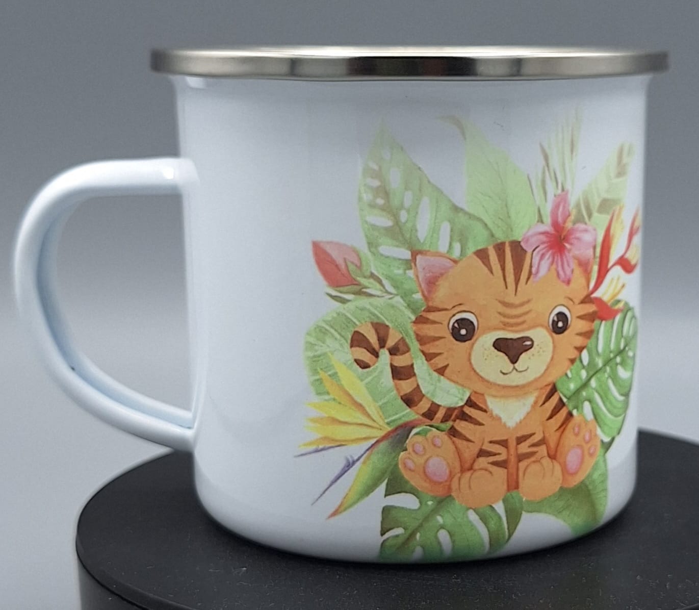 "Emailletasse ORCA mit Leopard-Motiv und grünem Blätterdesign auf weißem Hintergrund"