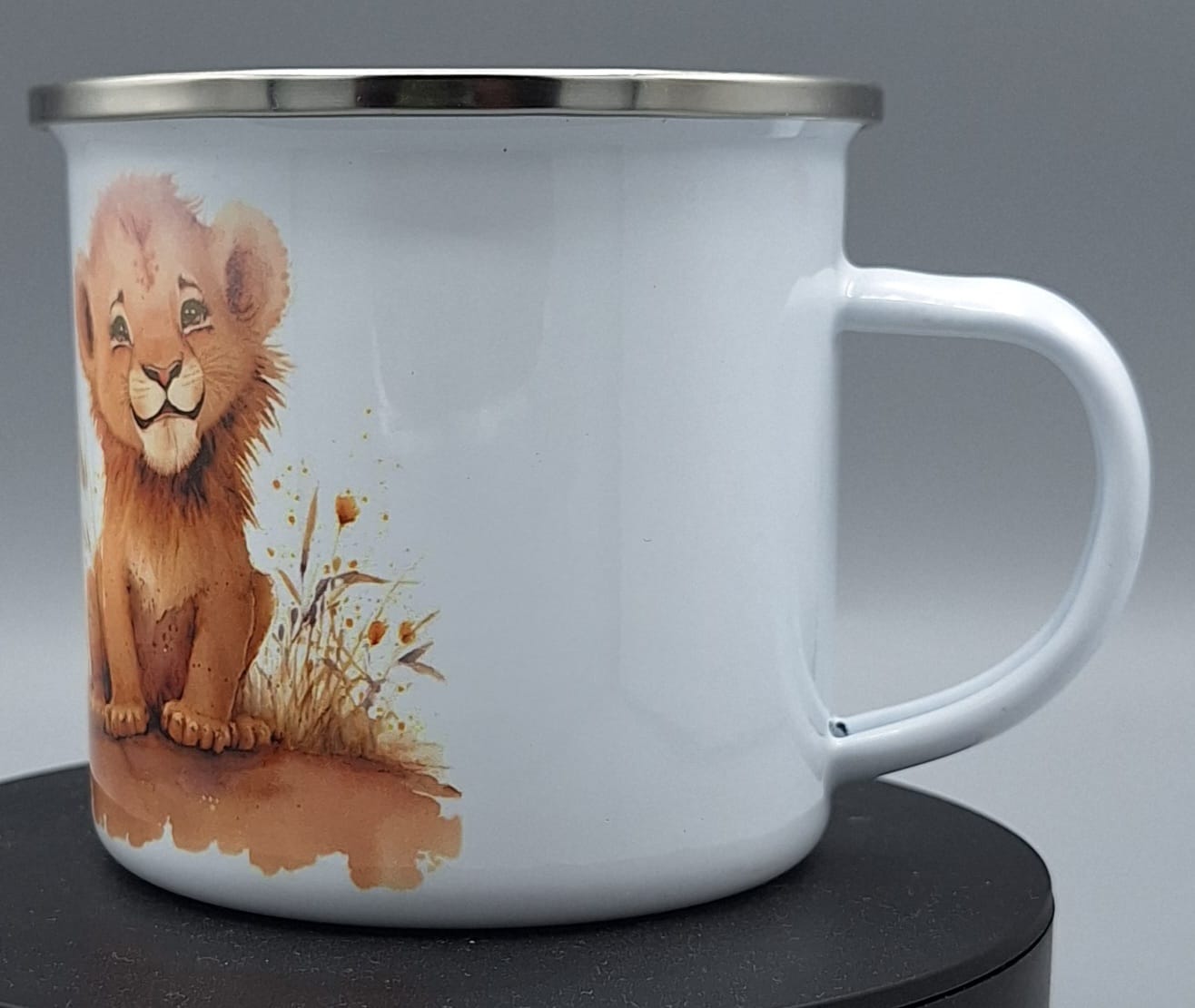 "Detailansicht Emailletasse mit niedlichem Löwenbaby-Design und Edelstahlrand"