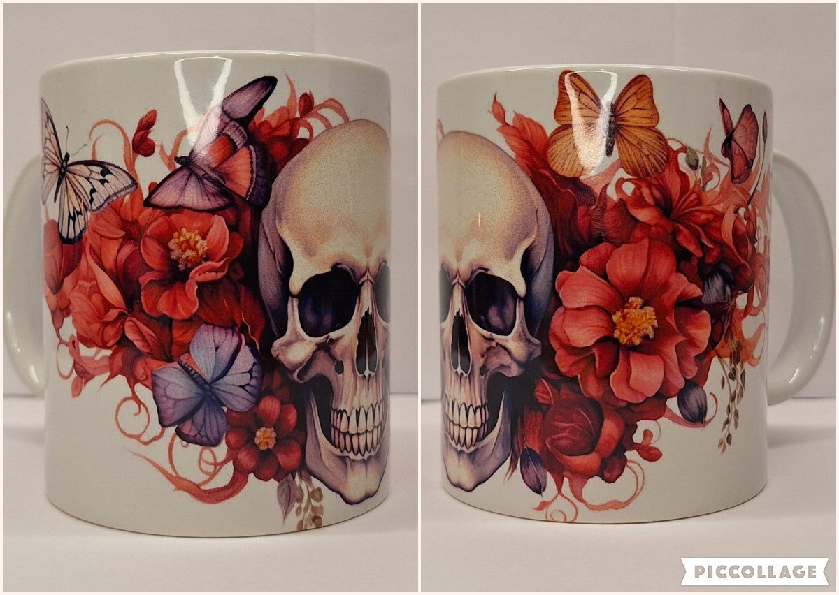 Weisse Keramiktasse mit stilisiertem Totenkopf, umgeben von roten Blumen und bunten Schmetterlingen; hochglänzende Orca-Keramik, C-Henkel – ideal als Gothic-Blumen-Deko für Kaffee- oder Teeliebhaber.